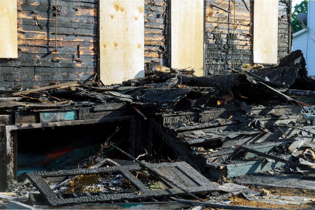 Abandoned building after fire house completely consumed by fire is burnt to the ground.